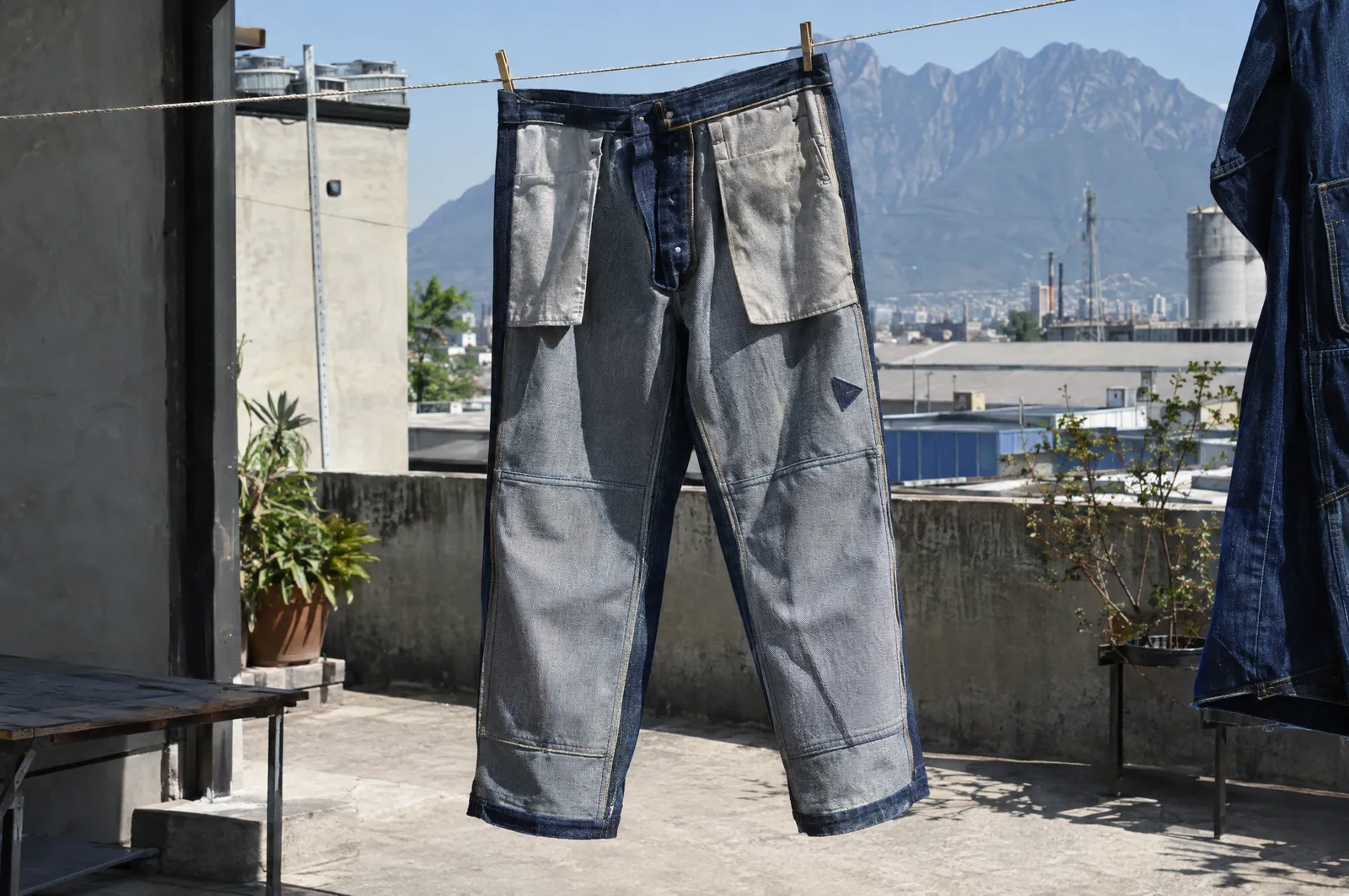 Pantalones de mezclilla de trabajo colgados al revés en un tendedero